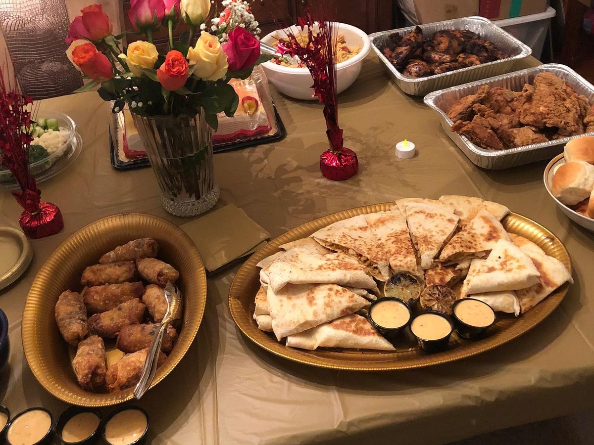 A catering table set with platters, rolls and flowers