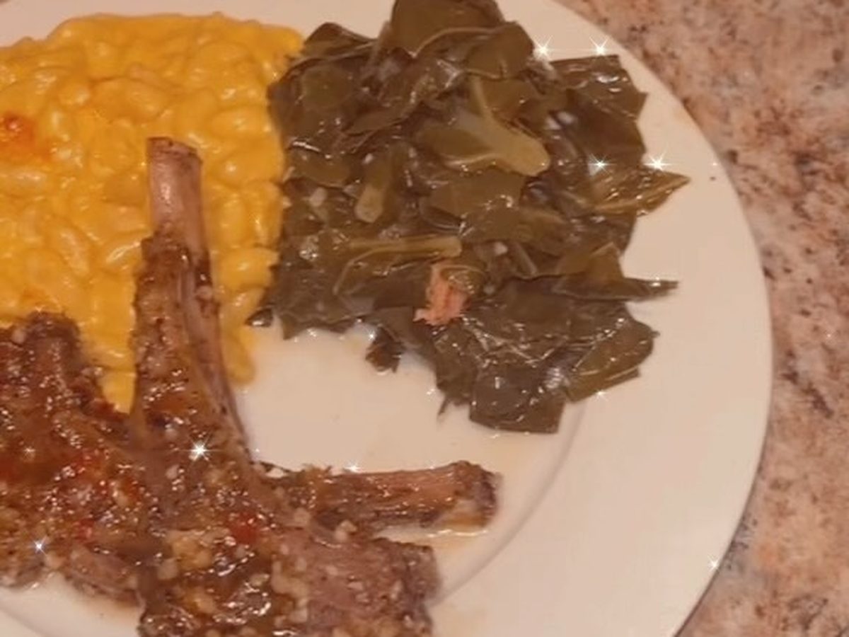 Grilled jerk lamb chops beside collard greens and macaroni on a white plate