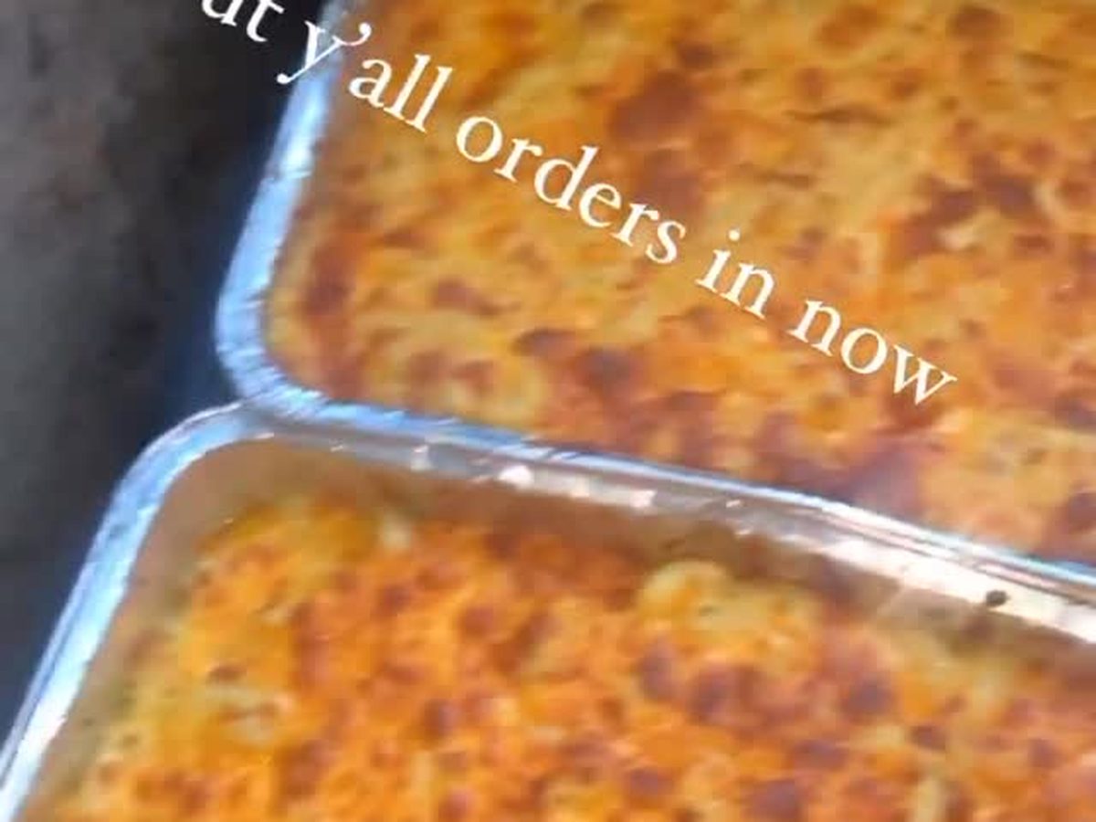 A full aluminum catering pan of baked macaroni and cheese with a browned top