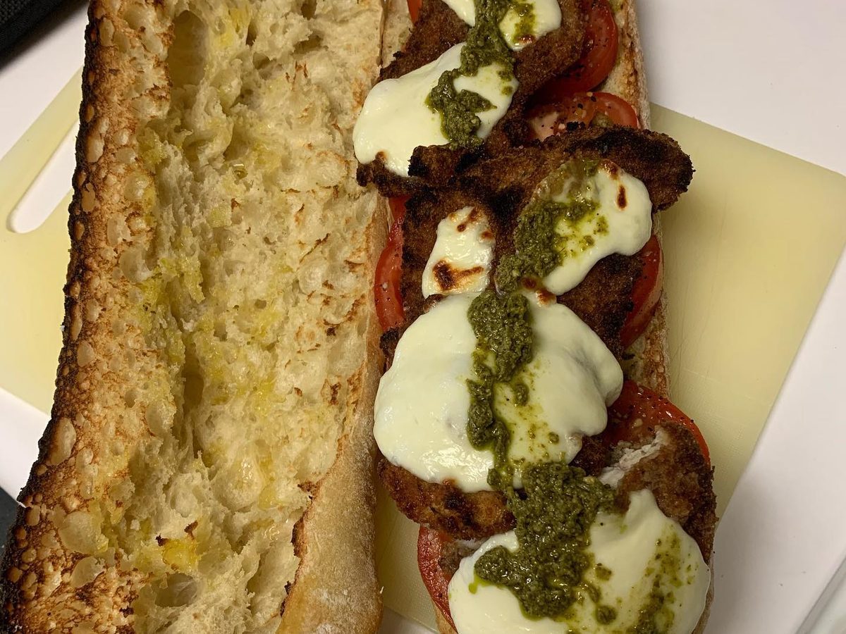 Toasted garlic bread topped with tomato, fresh mozzarella and pesto