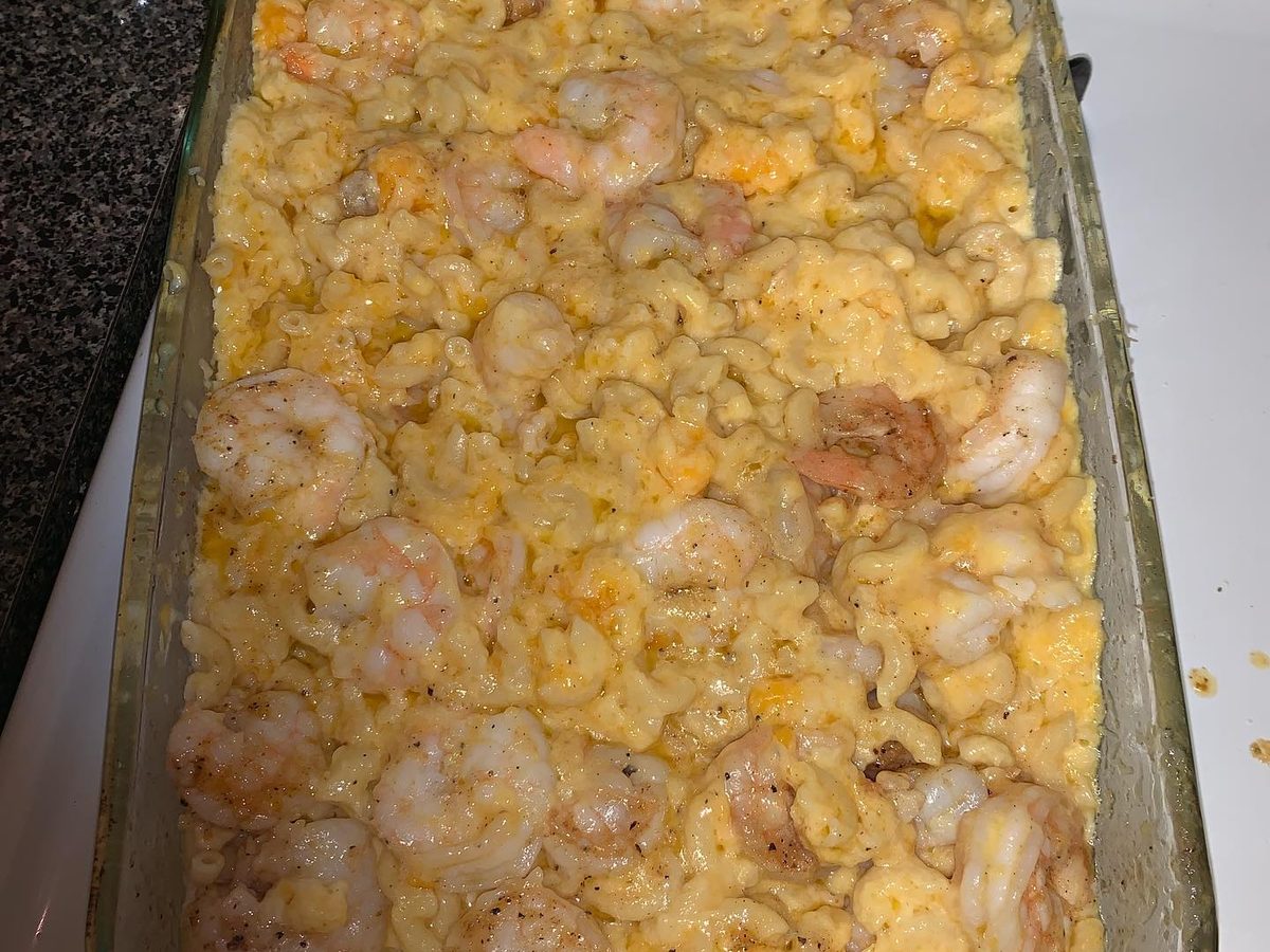 A large tray of baked macaroni and cheese packed with shrimp