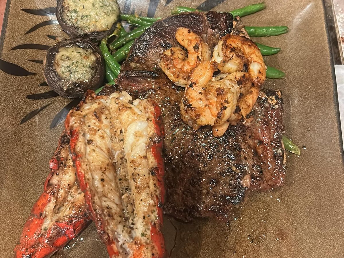 Steak with a split grilled lobster tail, grilled shrimp and stuffed mushroom caps