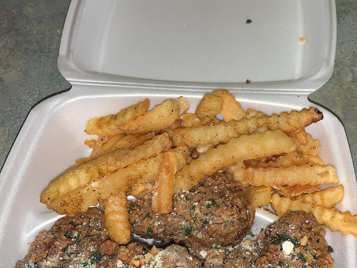Wings and crinkle-cut fries in a white takeout container